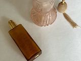 un petit flacon de parfum à côté d'un autre petit flacon de parfum