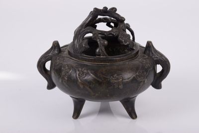 un petit pot en bronze orné de deux oiseaux