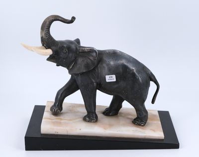 statue d'un éléphant avec des défenses, posée sur un socle en marbre
