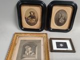 two framed pictures of a man and a woman in black frames