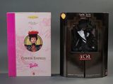 deux poupées en boîte représentant une femme en robe noire et une femme avec un chapeau rouge