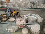 une vitrine en verre remplie de vaisselle et d'assiettes