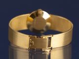 a close up of a gold bracelet with a heart on it