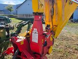 a red and yellow machine that is sitting in the grass