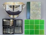 a silver bowl, silverware, and other silverware on a table