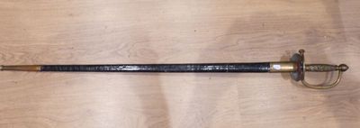 a close up of a sword on a wooden surface