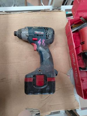 a cordless drill and a box of tools on a table