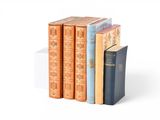 several books are stacked on top of each other on a white surface