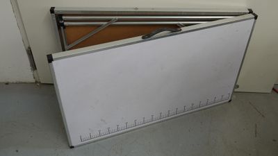 a white board on the floor with a ruler on it
