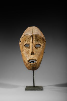 un masque en bois sur un support avec un fond noir