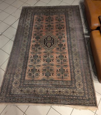 tapis posé sur le sol d'un salon où se trouvent un fauteuil et un canapé