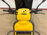 a yellow and black moped parked in a garage