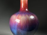 a purple and blue vase sitting on a wooden stand