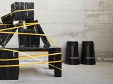 a chair made out of black plastic wrapped in yellow tape
