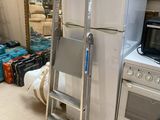 a ladder next to a refrigerator in a room