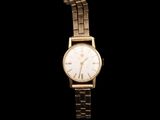 a close up of a gold watch on a black background