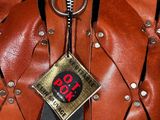 a close up of a leather jacket with a tag attached to it