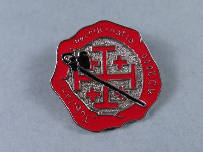a red and silver pin with a chinese symbol on it