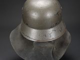 an old silver helmet on a black background with a shadow on the ground