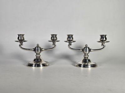 une paire de chandeliers en argent sur fond blanc