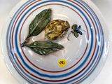 une assiette sur laquelle est représentée une fleur et une feuille