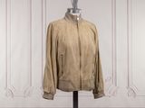 an image of a tan jacket on a mannequin stand in front of a white wall