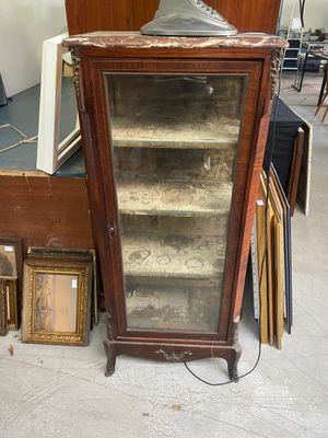 une vitrine en verre surmontée d'une horloge, dans une pièce