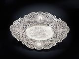 une assiette ancienne en argent sur laquelle est représenté un homme et une femme