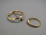 deux bagues en or et une bague en or sur un fond gris