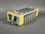 a model of a yellow building with a blue door and windows