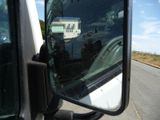 a reflection of a building in the side mirror of a truck