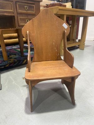 une chaise en bois qui se trouve dans une pièce