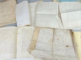 quelques vieux papiers sont posés sur une table, à côté d'une paire de ciseaux