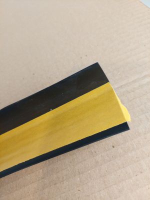 un morceau de bois peint en jaune et noir
