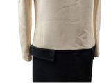 the back view of a woman ' s beige sweater with a black belt on a mannequin mannequin mannequin mannequin mannequin mann