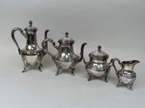four pieces of silver tea and coffee set on a white background