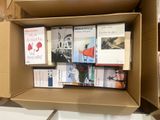 many books in a cardboard box on a shelf