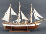 une maquette en bois d'un voilier aux voiles blanches