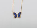 a gold necklace with a blue butterfly pendant on it