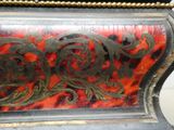 une horloge rouge et noire ornée de motifs dorés