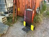 un radiateur rouge et noir posé à côté d'un conteneur métallique