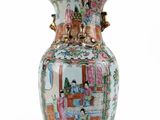 a vase with a painting on it sitting on a table