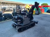 the back end of a small excavator parked in front of a building