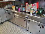 a kitchen counter with a lot of clutter on top of it
