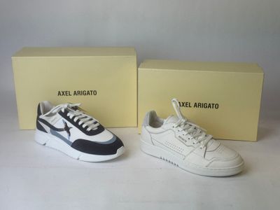 two pairs of white and black sneakers with a box in the background
