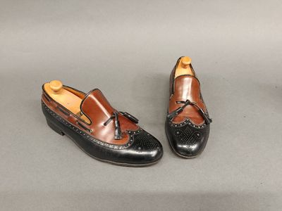 une paire de chaussures noires et marron posées sur une surface grise