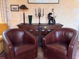 deux fauteuils en cuir marron placés l'un à côté de l'autre dans un salon