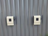 deux prises électriques blanches sur le côté d'un bâtiment métallique