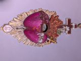 une image représentant un masque rose et doré orné d'une croix