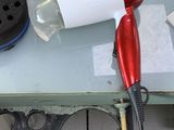 a red blow dryer sitting on top of a table